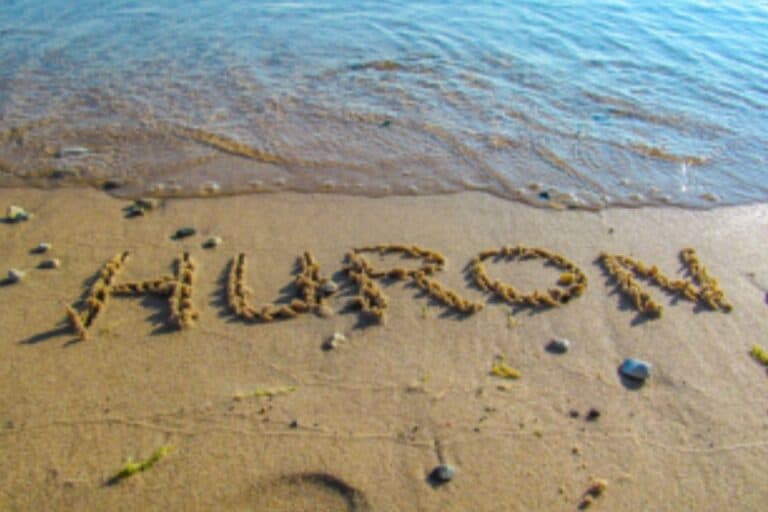 Lake Huron shoreline with word Huron written in sand at water’s edge