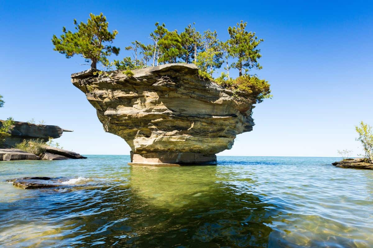 a giant rock protruding out of the water in port austin mi