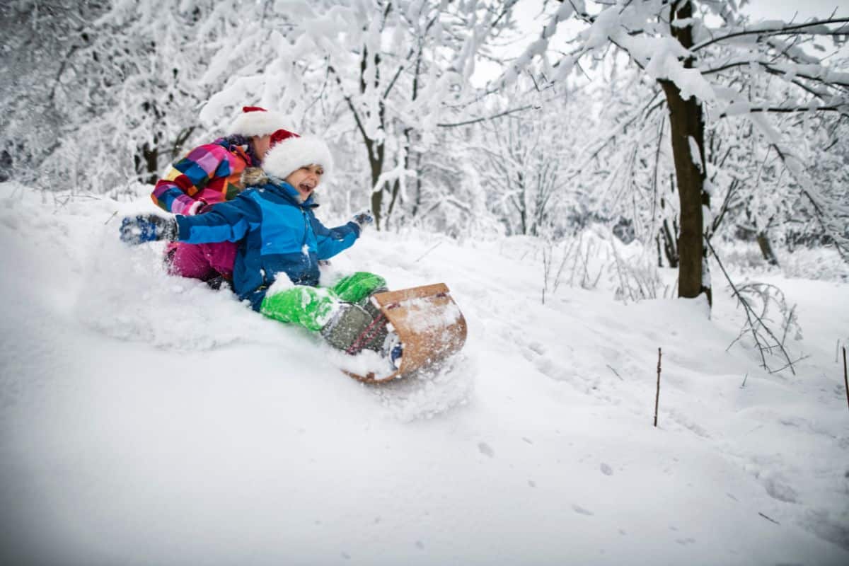 Kids tobogganing in michigan on a snowy winter day