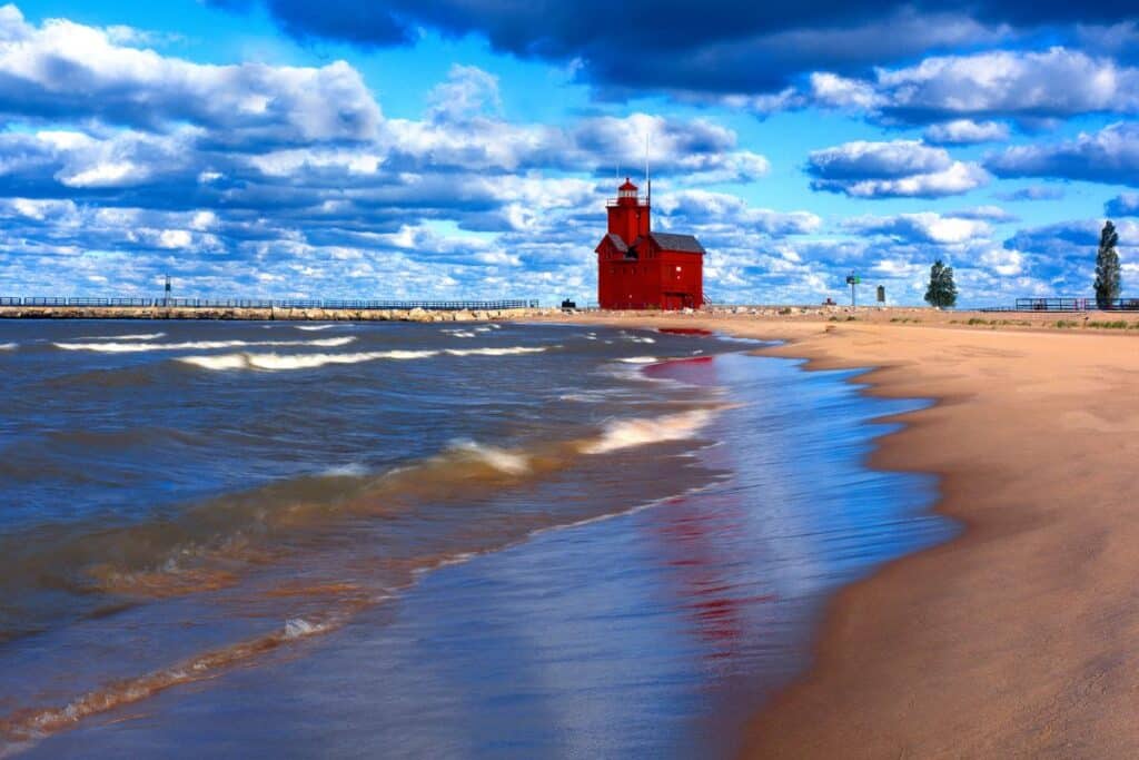 beach with red lighthouse in background 