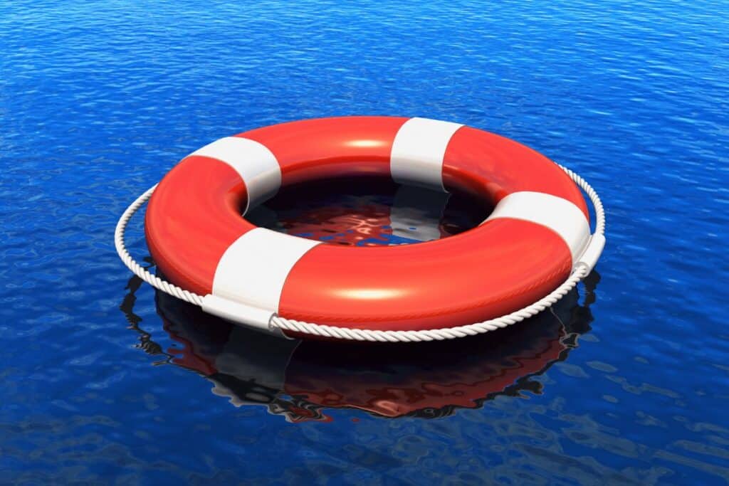 red life-saving ring floating on a blue lake