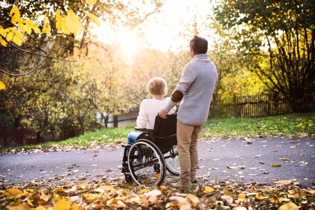 woman in weheelchair being pushed by man on a michigan hiking trail  