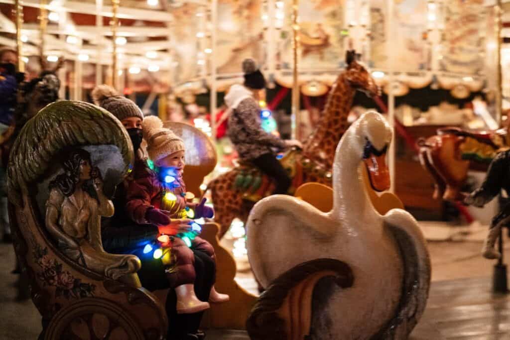 kids riding the merry go round at Greenfield village during holidays nights event