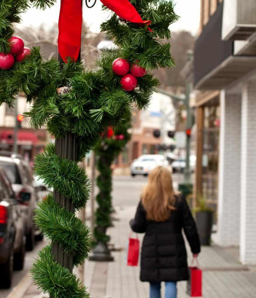 woman walking down street under chistmas decorations 