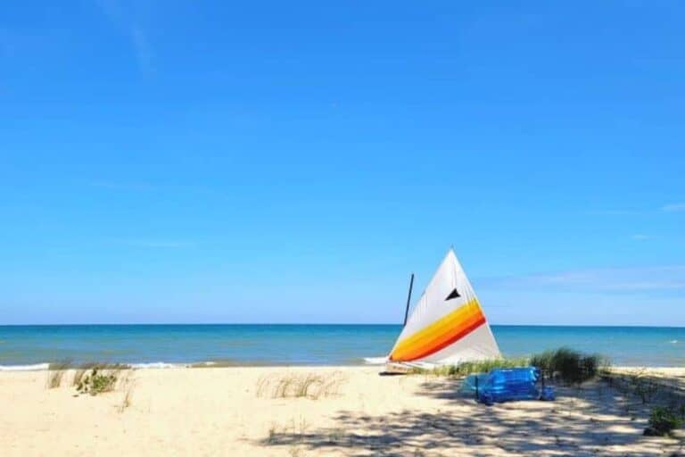 colorful sailboat on sandy Lake Huron beach in Michigan Thumb region with clear blue water