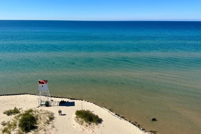 lake michigan with ludington lighthouse on beach