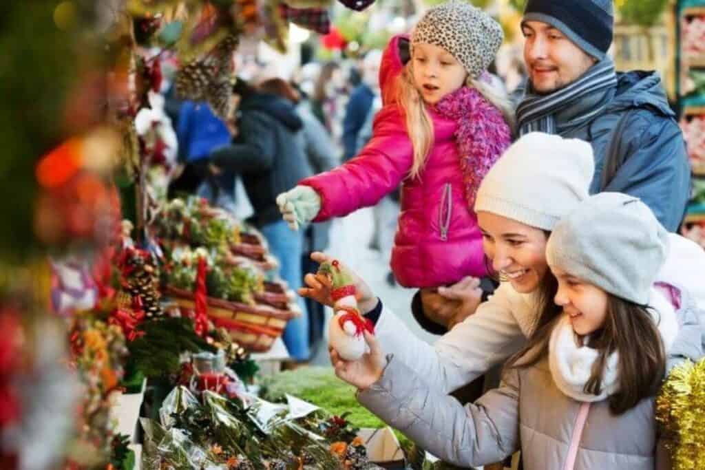 a family picking out Christmas ornaments at a michigan Christmas event
