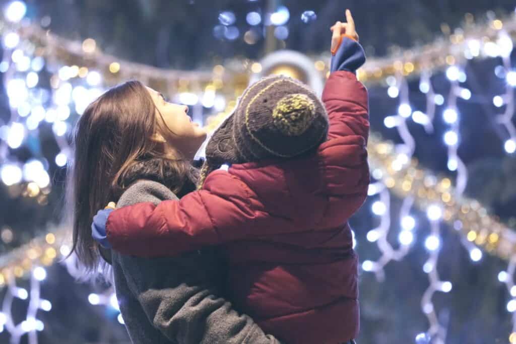 mother showing her child Christmas lights in Michigan, a favorite holiday event