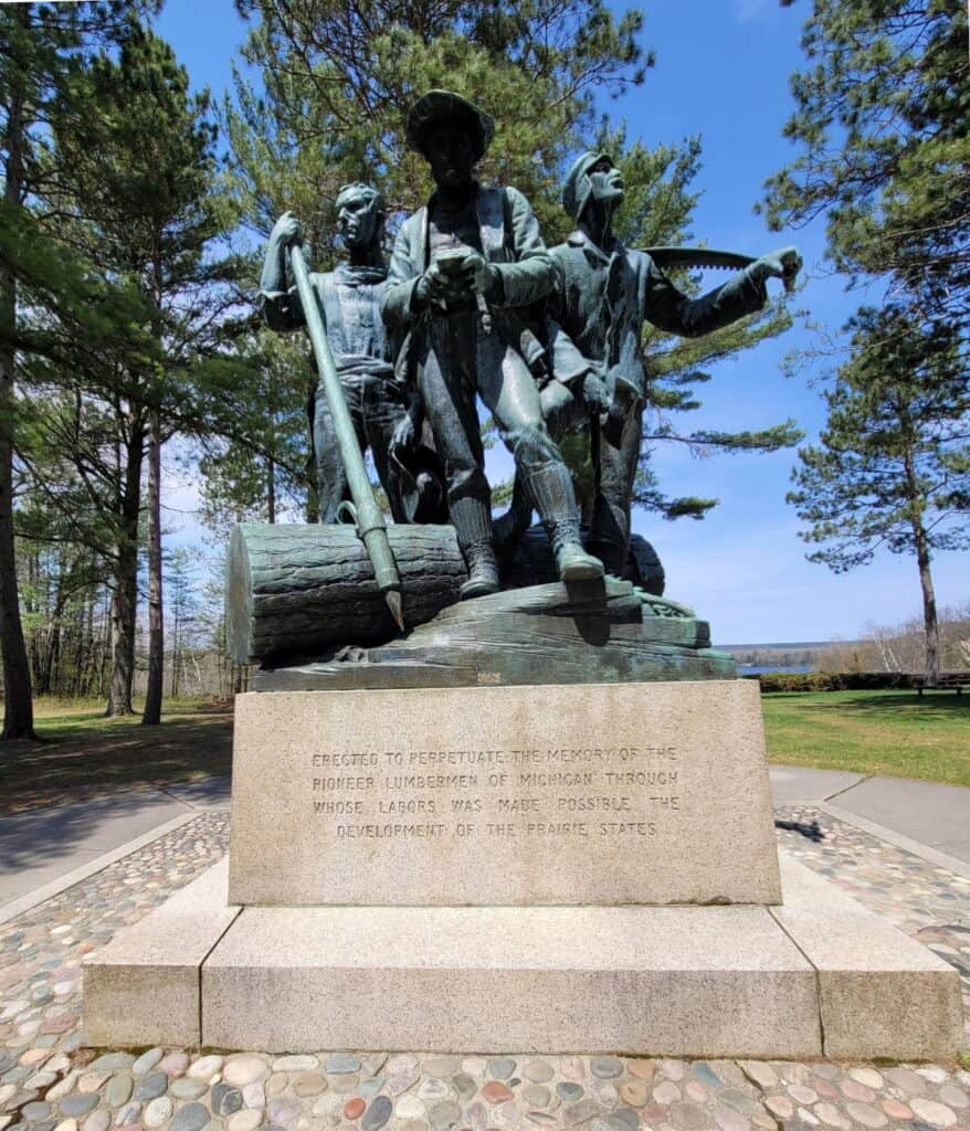 Lumberman's Monument bronze statue of three pioneer loggers on the Au Sable River near Oscoda Michigan