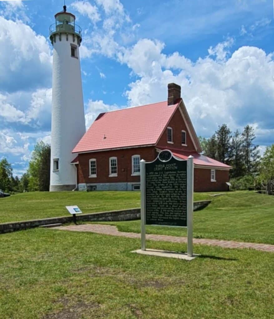 Tawas Point Light Station with white tower and red-roofed keeper's house in East Tawas Michigan
