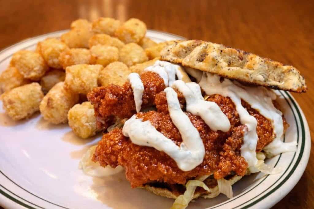 crispy chicken sandwich with sauce and tater tots at Clementine’s restaurant in South Haven Michigan