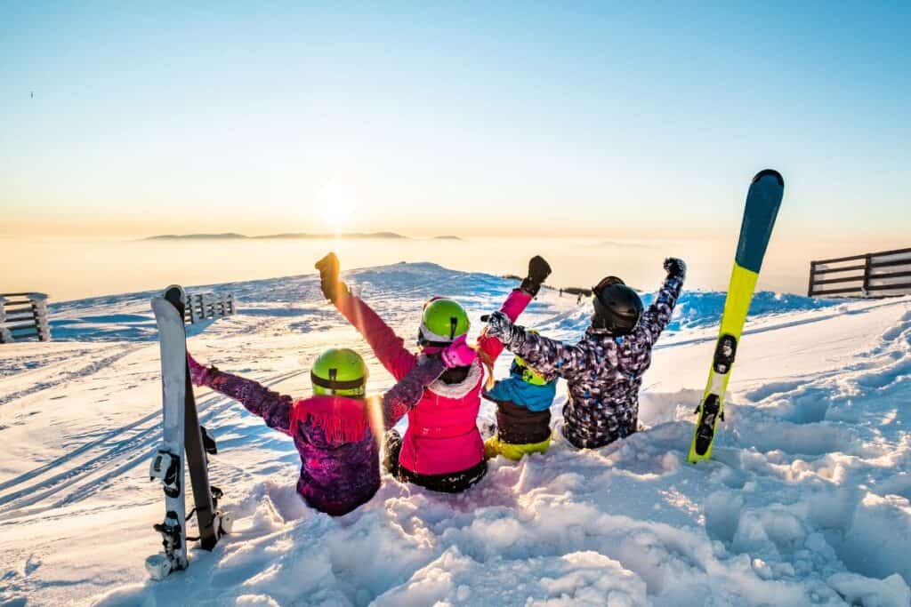 children sitting down on a ski mountain in march