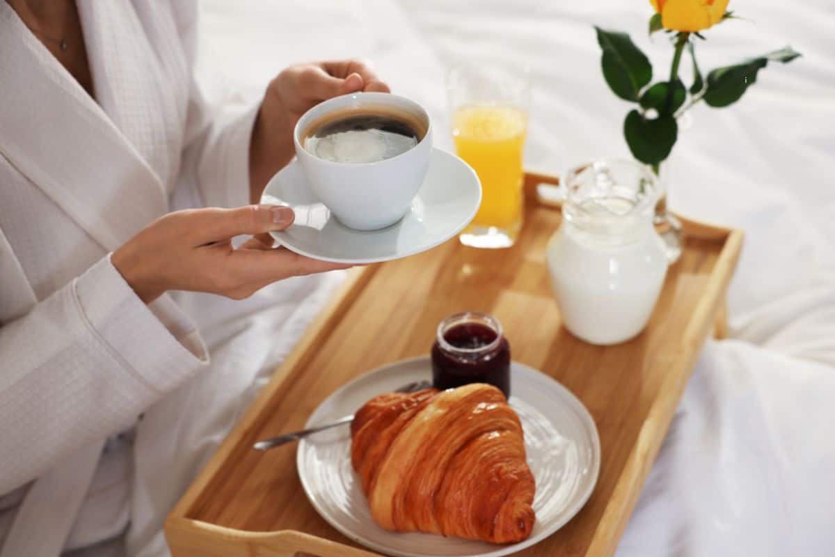 Coffee, croissant, jam, and orange juice on a breakfast tray in bed at a St. Joseph Michigan bed and breakfast