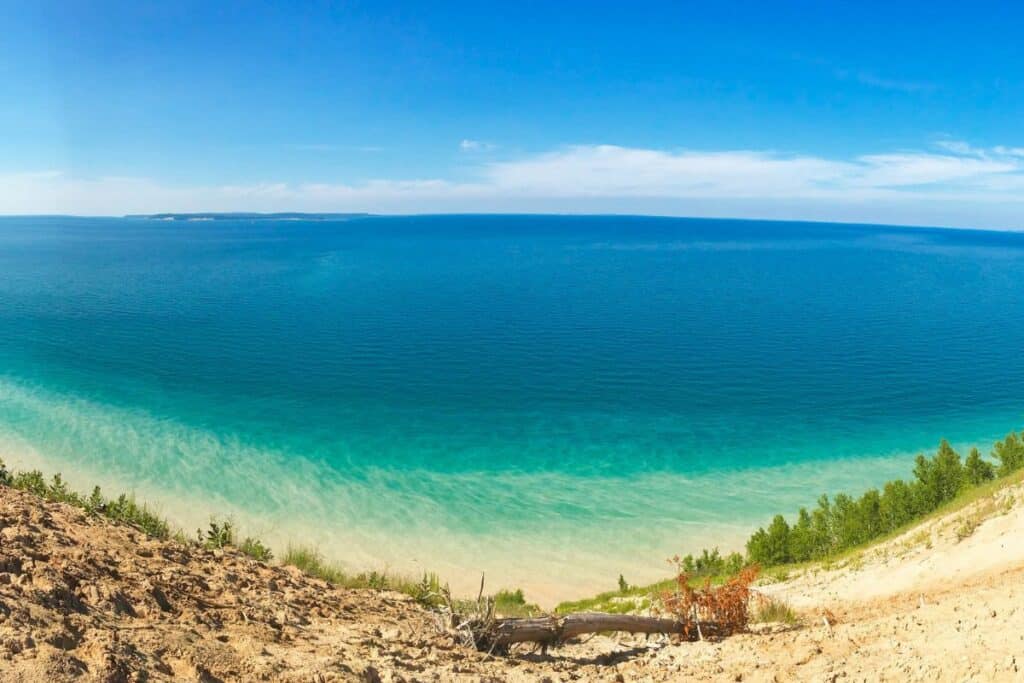 Wooden boardwalk railing along Pyramid Point Trail with turquoise Lake Michigan and Sleeping Bear Dunes shoreline visible below