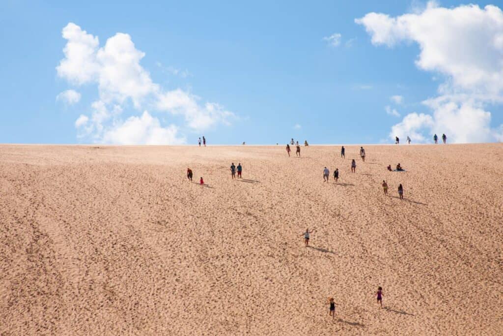 Wooden boardwalk railing along Pyramid Point Trail with turquoise Lake Michigan and Sleeping Bear Dunes shoreline visible below