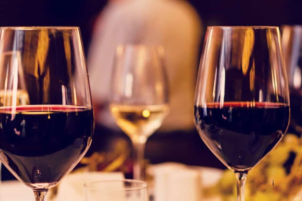 Two glasses of red wine and a glass of white wine on a table at a St. Joseph Michigan restaurant