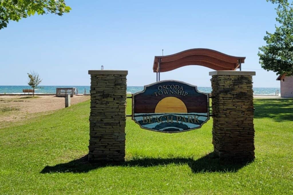  Blue Oscoda AuSable Naturally entrance sign for Oscoda Beach Park with activity icons in Oscoda Michigan