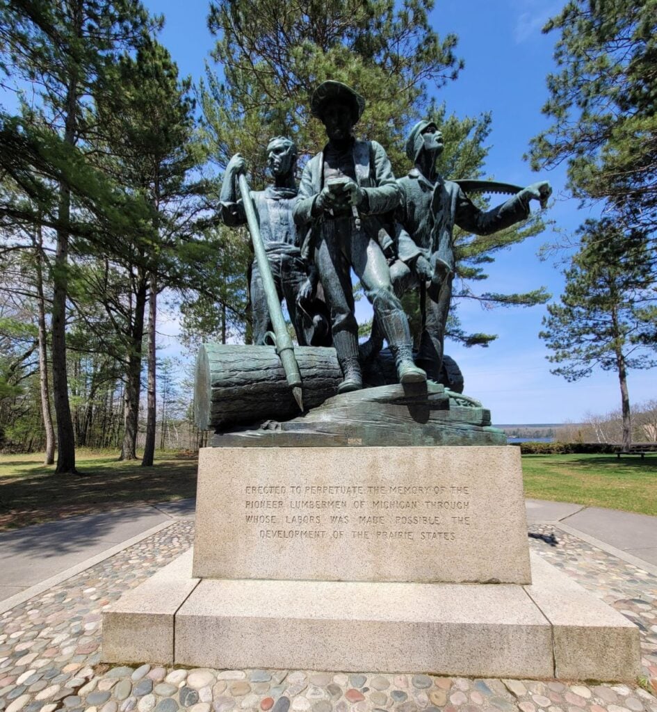 The bronze Lumberman's Monument near Oscoda, Michigan, showing three pioneer lumbermen with a peavey, crosscut saw and log